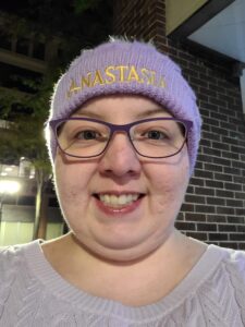 A woman dressed in all purple wearing a hat featuring one of their favorite theatre productions, Anastasia.